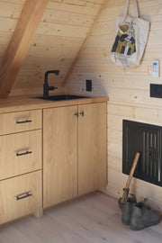 Bivvi Camp cabin with white oak flooring by Stuga, wood cabinets, and pine paneling