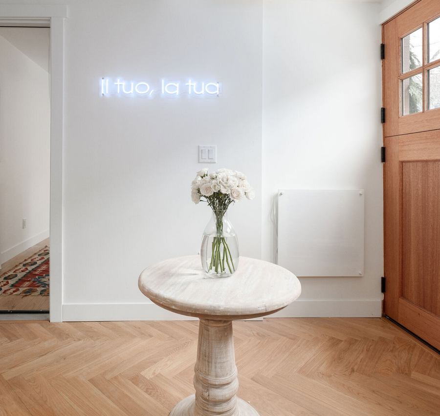 Natural herringbone wood flooring in an entryway with a marble pedestal table