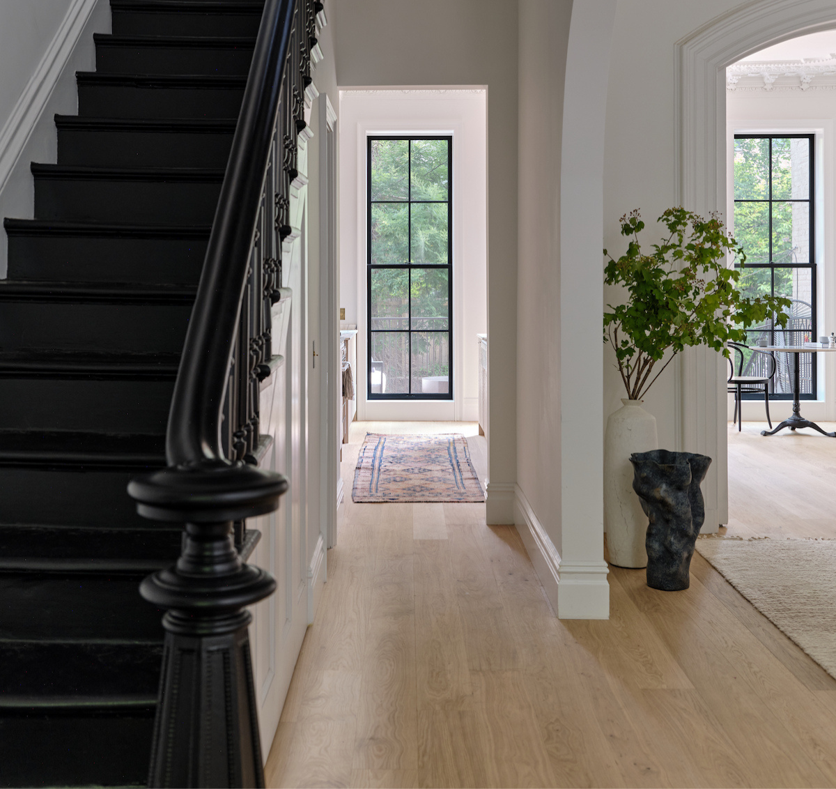 A black staircase with modern white oak flooring