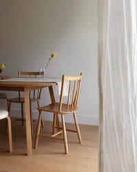 Greta modern white oak flooring by Stuga in a dining room with gauze curtain