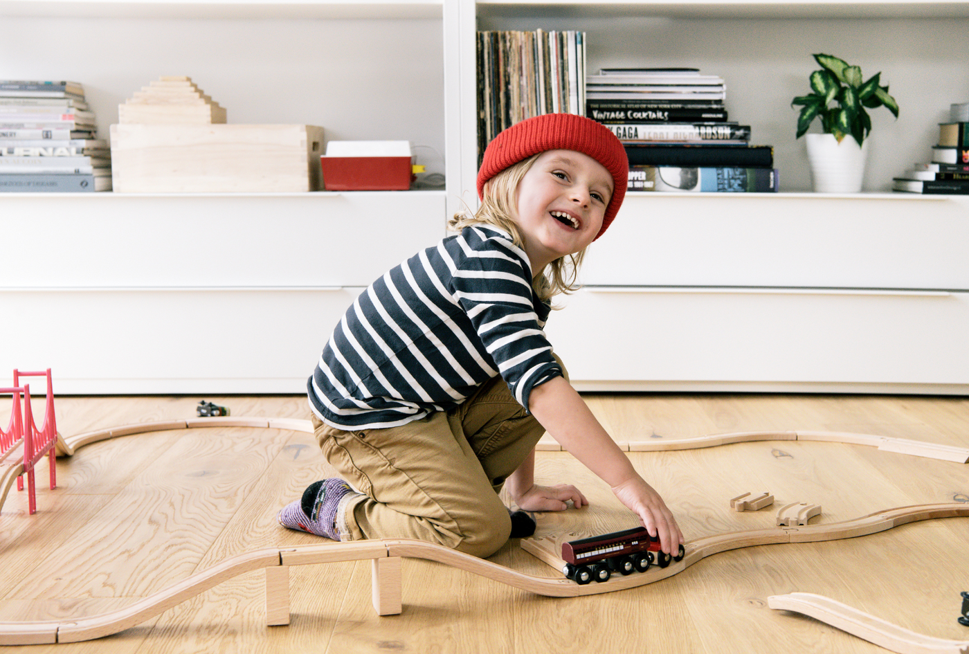 Child playing with Brio train set on nontoxic hardwood flooring