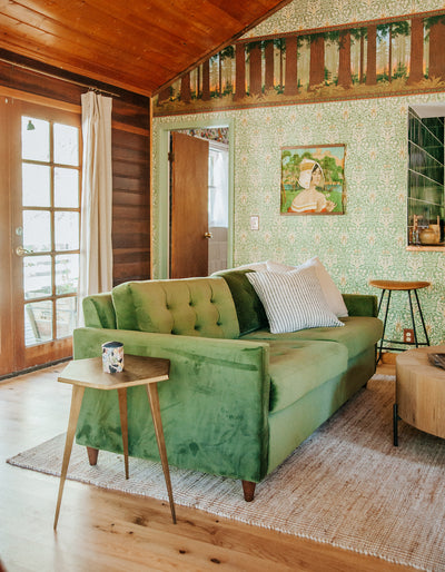 Cabin living room with green couch and Forest natural white oak flooring by Stuga