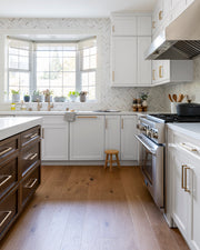 Warm white oak flooring in a transitional white kitchen