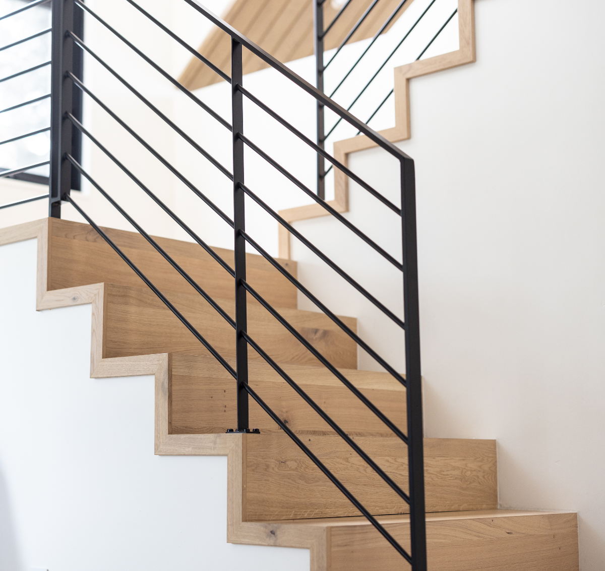 Flush stair nosings on a modern open stringer staircase with edge caps by Stuga