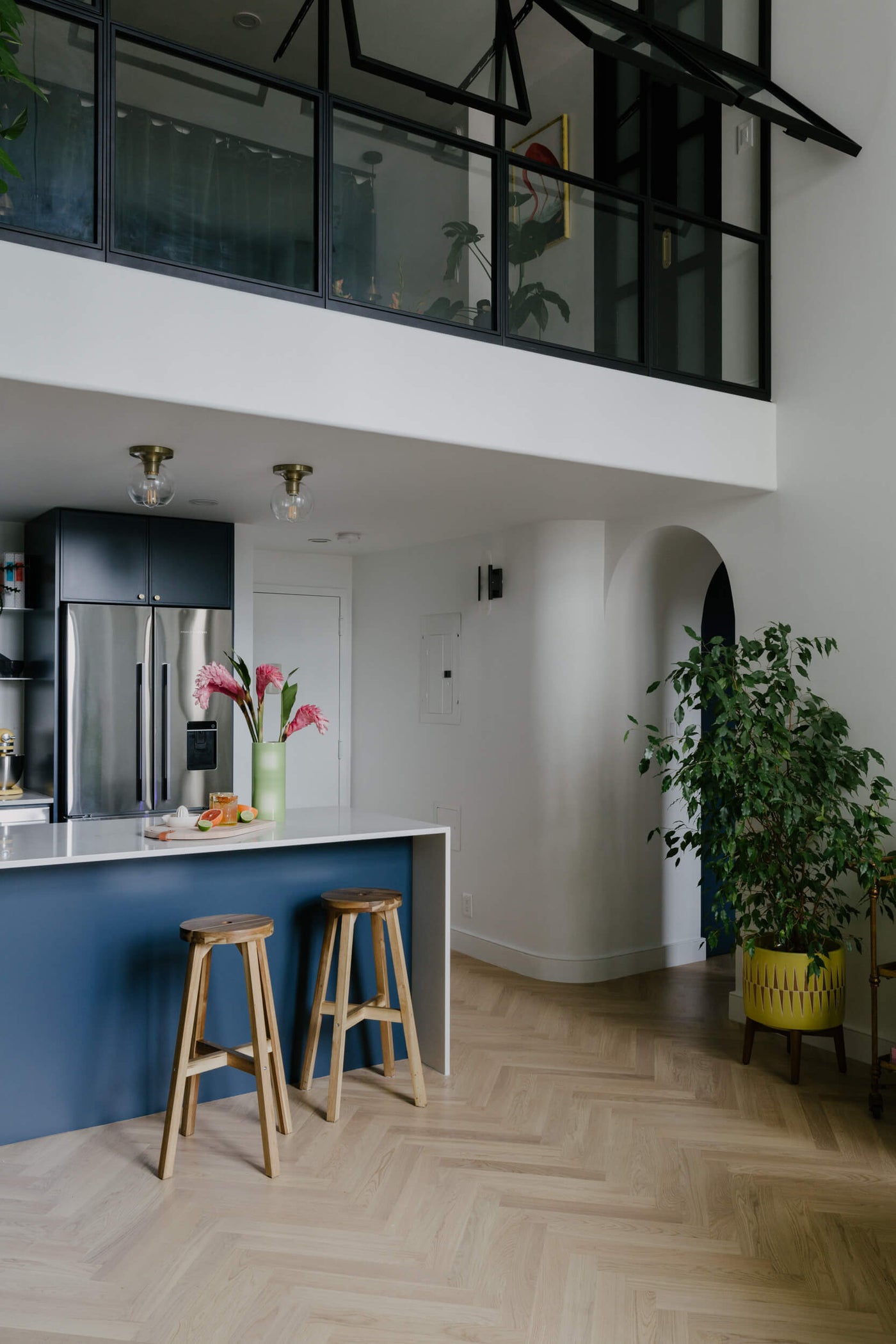 Modern blue kitchen with herringbone wood flooring