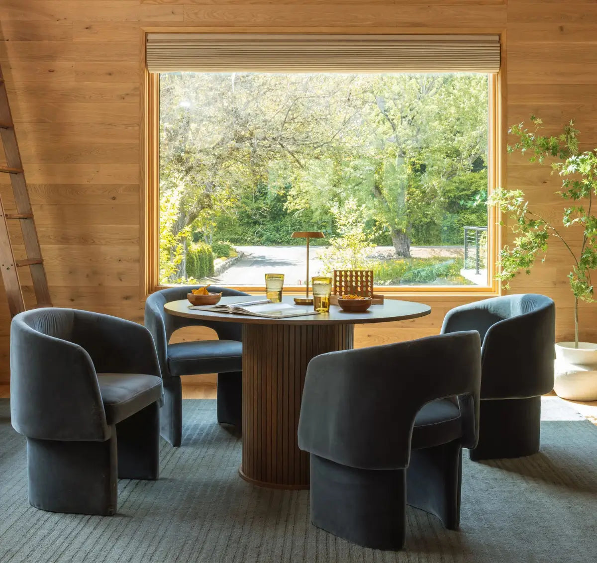 Modern dining area with walls clad in warm wood flooring by Stuga