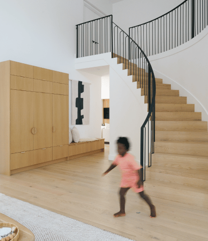 Young girl running down modern staircase with flush stair nosings in Fika by Stuga