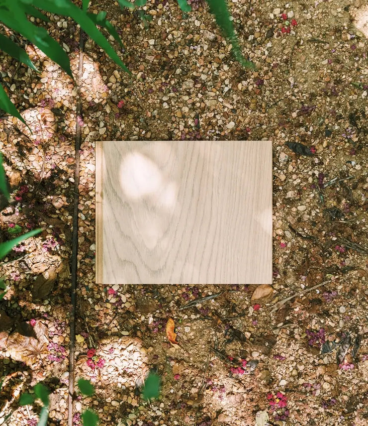 Half Pipe waterproof wood flooring sample on rocks with flowers and grasses