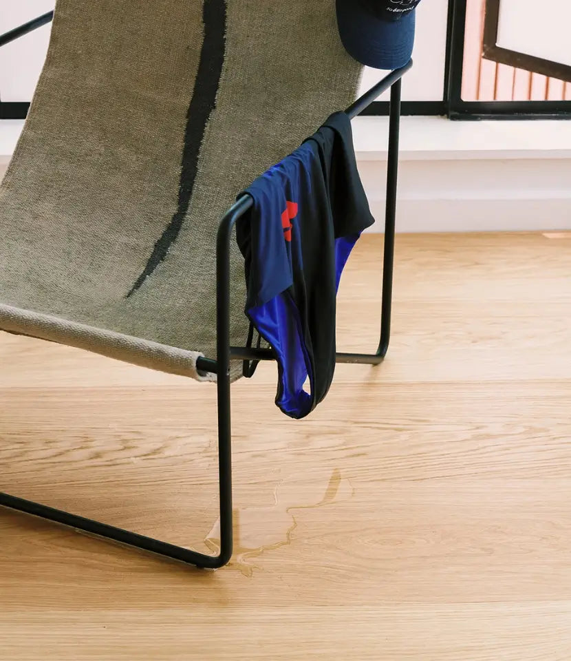 waterproof wood flooring with dripping swimsuit draped over chair