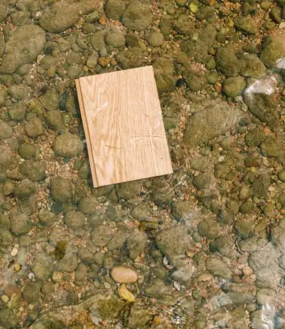 High Five waterproof wood flooring sample in a rocky river bed