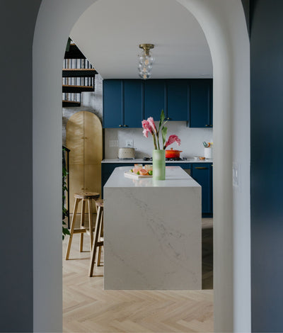 Modern blue kitchen with natural oak herringbone wood flooring