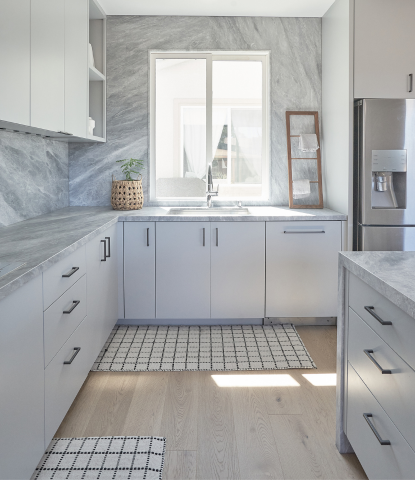 Modern matte hardwood flooring in a minimalistic kitchen with white cabinets and natural stone