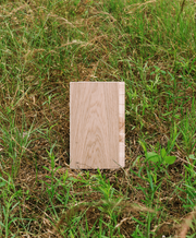 Modern white oak flooring sample in a field of grasses