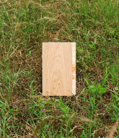 Modern white oak flooring sample in a field of grasses