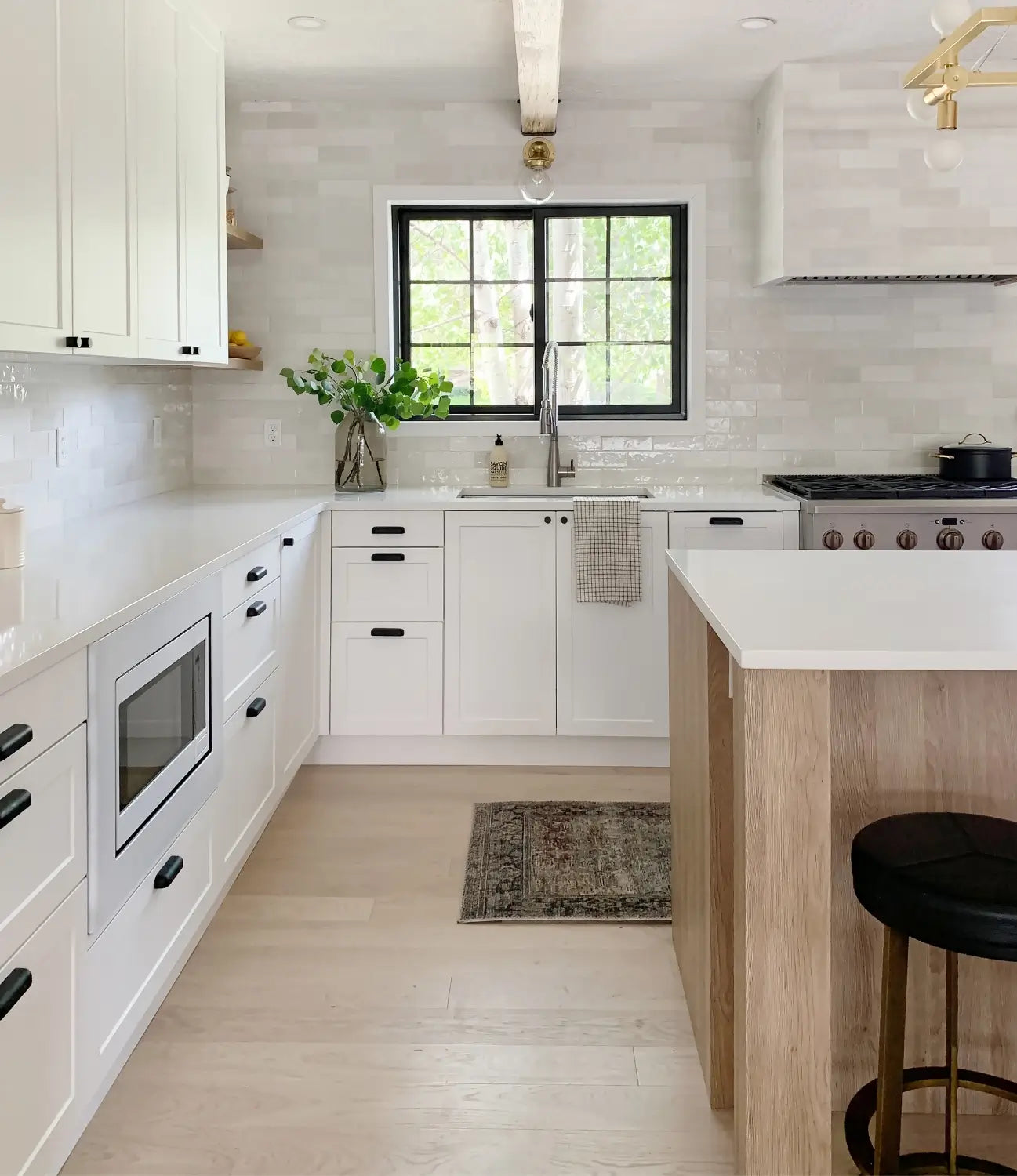 Kitchen renovation with white oak engineered flooring and white cabinets featuring Moonlight by Stuga