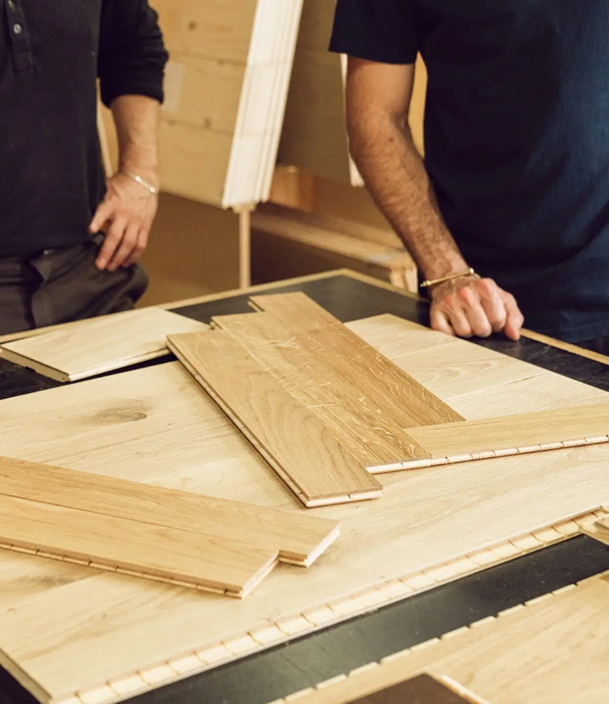 Stuga employees show how herringbone flooring planks come together in sample shop