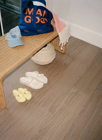 Muted gray wood flooring with pool supplies under a bench