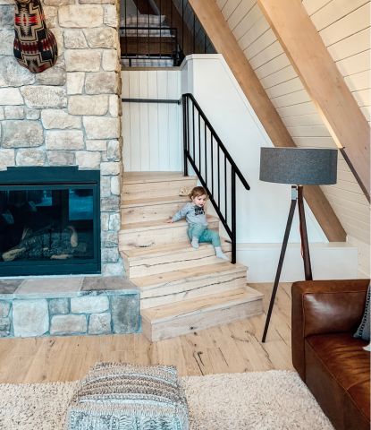 Chris Loves Julia cabin with rustic wood flooring and a girl on staircase