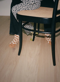 Closeup of blonde wood flooring under a chair