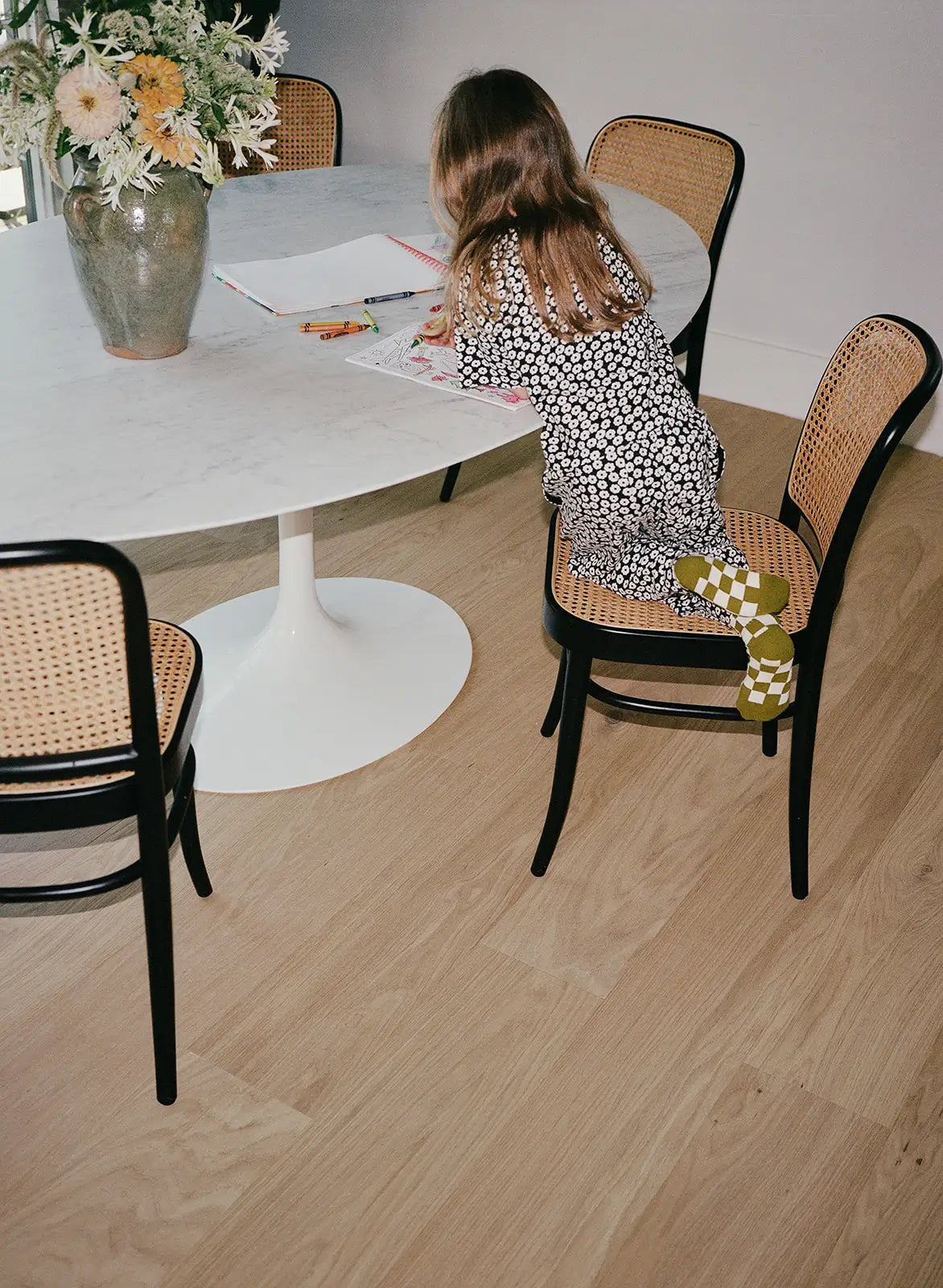 Kid coloring at a table on durable blonde oak flooring