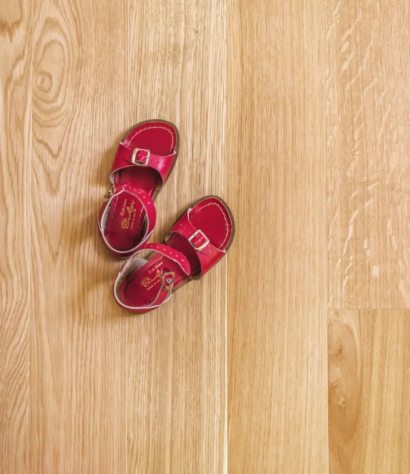 Child's red sandals on Scandinavian white oak flooring by Stuga with medullary rays 