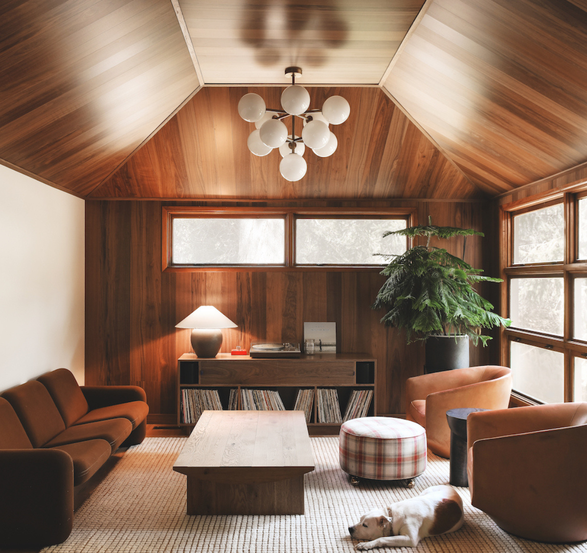 A midcentury living room with brown furniture and walnut flooring on the ceiling