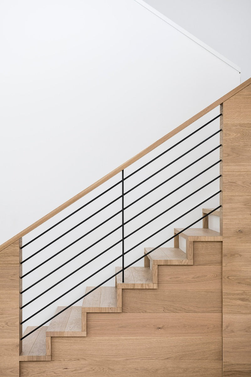 Modern staircase with white oak hardwood flooring and black railing