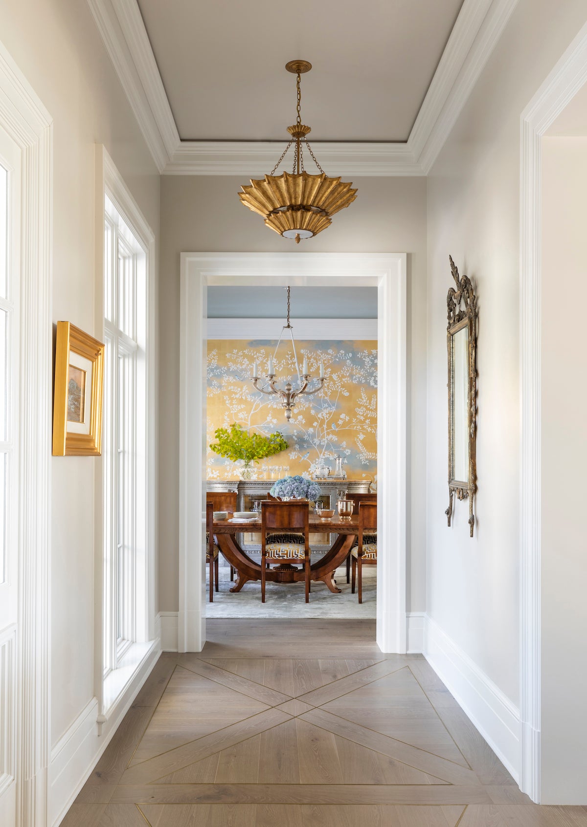 Gray Scandinavian engineered wood floors in an Austin, TX home's hallway. Laid in an inlay pattern with brass details.