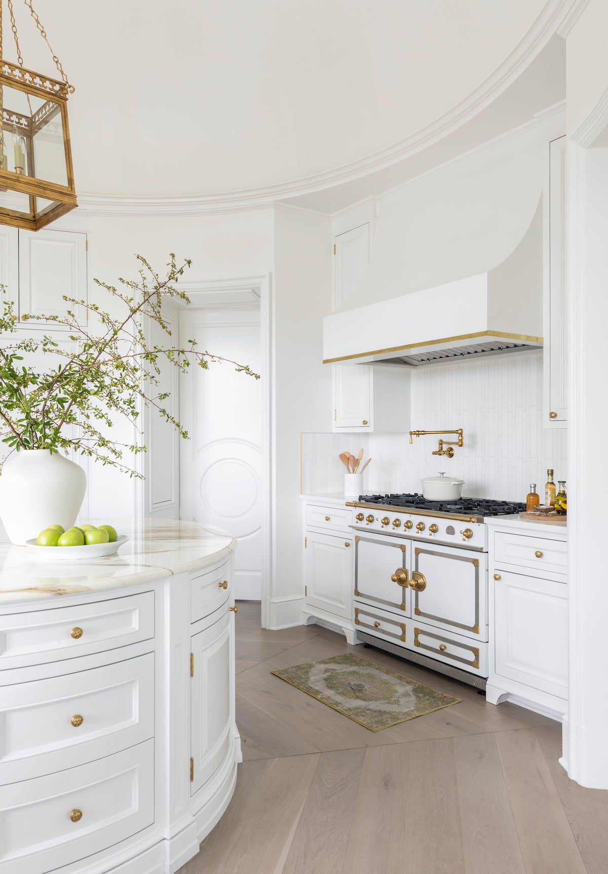 Gray Scandinavian engineered wood floors laid in a rounded pattern in a kitchen with a circular island.