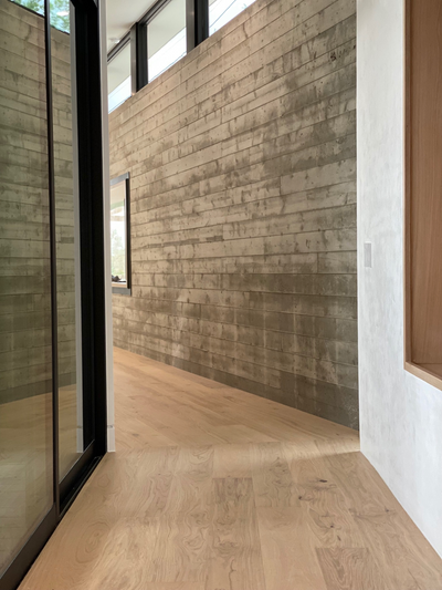 Greta modern white oak flooring by Stuga in a hallway with concrete and plaster walls