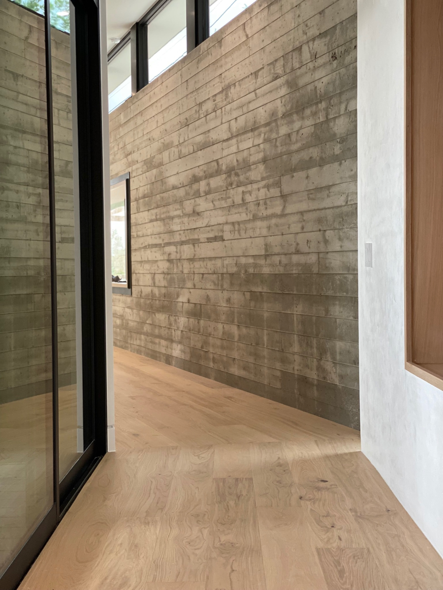Greta modern white oak flooring by Stuga in a hallway with concrete and plaster walls