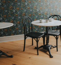 Faye by Stuga in the Chris Loves Julia office with a bistro table and floral wallpaper