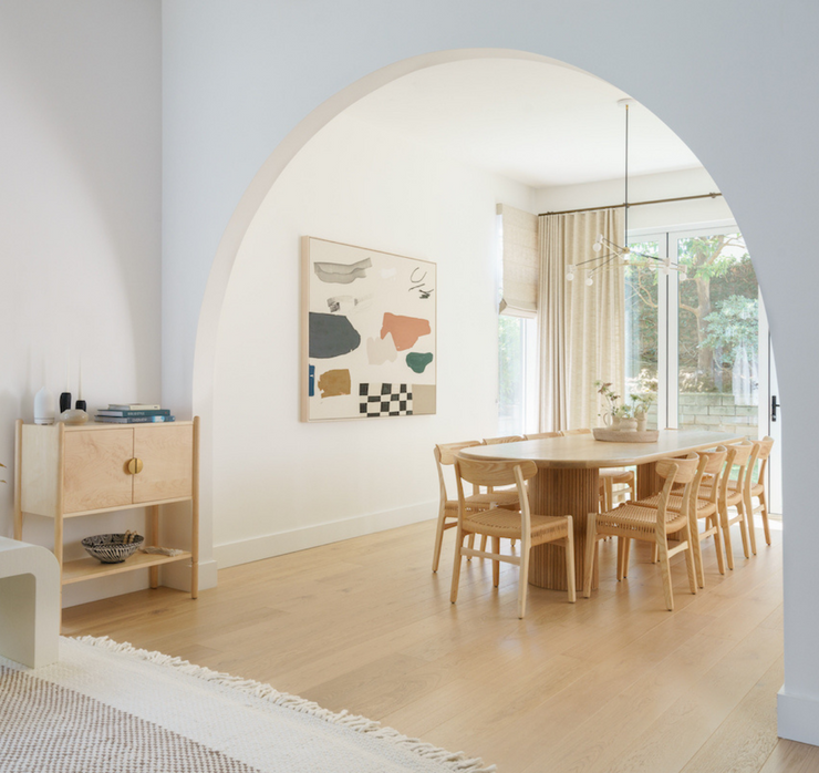 White archway dining room area featuring Stuga Fika Scandinavian wood flooring
